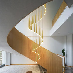 Spiral LED chandelier hanging through a modern staircase opening