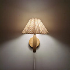 Wall-mounted lamp with woven shade on a plain wall