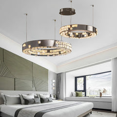 Modern bedroom with three circular pendant lights hanging above a bed.