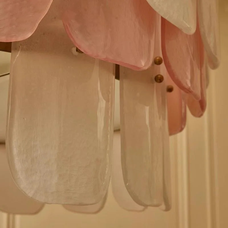Close-up of a pink and clear chandelier with gold fixtures.