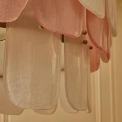 Close-up of a pink and clear chandelier with gold fixtures.