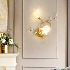 Decorative wall lamp with floral design on a neutral wall, next to a fireplace with flowers.