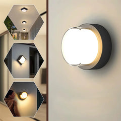 “Round black LED moon wall lamp casting soft light on a modern exterior wall.”