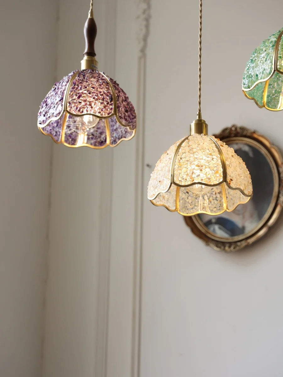 Two decorative pendant lights hang against a neutral wall—a hand-laid green crystal glass ceiling light, energy-saving, creative home lighting.