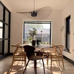 Dining room with a round table and chairs, large window, and modern pendant light.