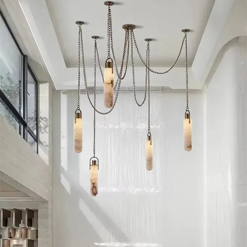 Chain-suspended marble pendant lights arranged at varied heights