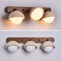 “Modern vanity wall sconce with stone shades casting downward light above a mirror.”