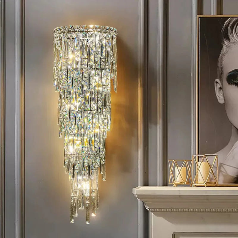Crystal wall sconce on a gray wall with a framed portrait and candle holders.