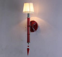 Decorative wall lamp with red and silver design on a white wall